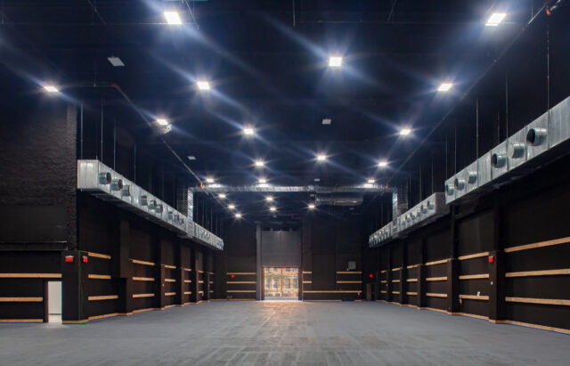 Soundstage on ground floor of building as a large open floor space with black interior walls and bright lighting from the ceiling.